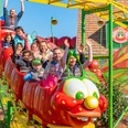 Karls Erlebnishof - Ausflugsziele in der Region Leipzig Auf dem Bild ist die Raupenbahn im Freizeitpark Karls Erlebnisdorf zu sehen. Mehrere Kinder sitzen in den bunten Waggons der kleinen Achterbahn und jubeln vor Freude.