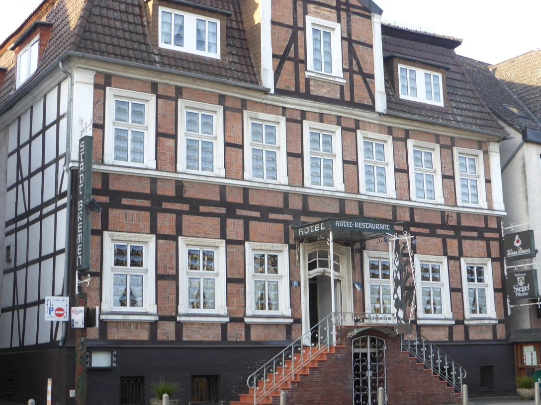 Fachwerkhaus mit breiter Treppe und vielen Fenstern.