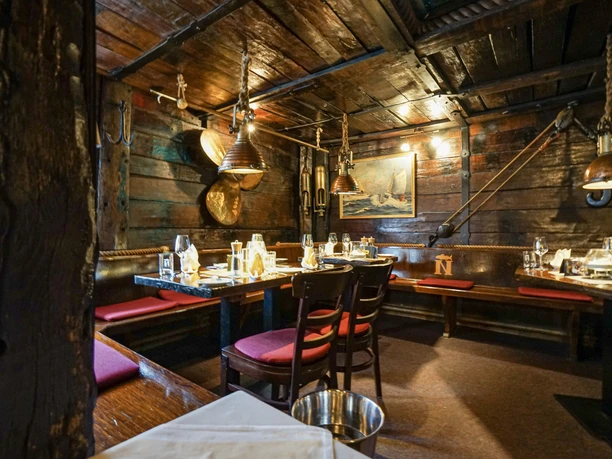 Natusch InstaWalk Fischereihafen (c) Thorben Strümpel (1).jpg Holzvertäfelter Gastraum mit maritimer Dekoration und gedeckten Tischen im Natusch Fischereihafen.