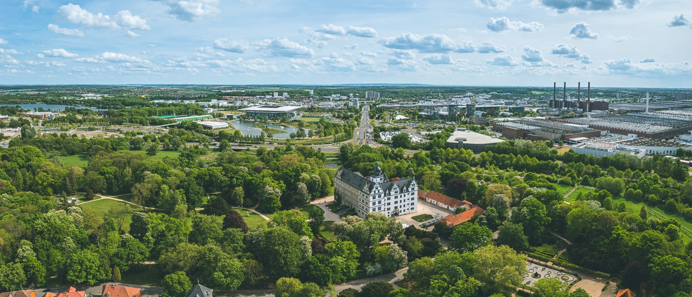 Wolfsburg von oben Luftaufnahme von Wolfsburg mit Schloss, grünen Parkanlagen und Blick auf das Volkswagenwerk.
