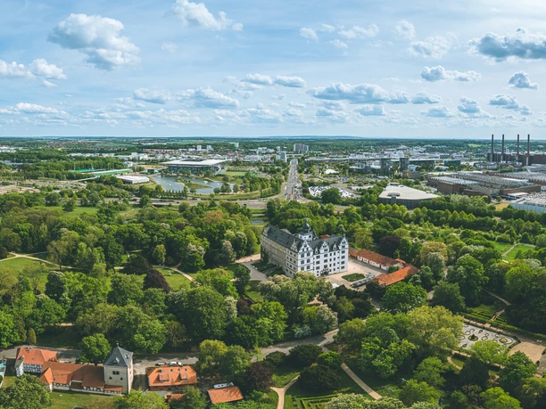 Wolfsburg von oben Luftaufnahme von Wolfsburg mit Schloss, grünen Parkanlagen und Blick auf das Volkswagenwerk.