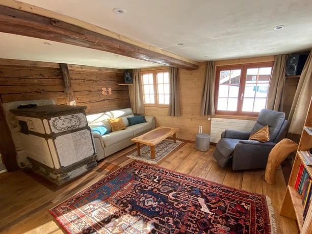 Wohzimmer mit Kachelofen und Sofa-Doppelbett