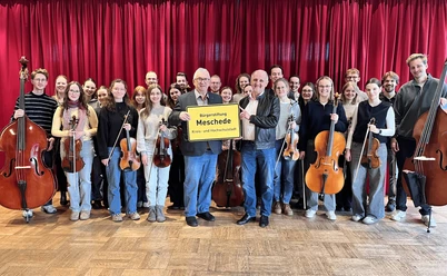 Junges Kammerorchester Meschede mit Streichinstrumenten vor rotem Bühnenvorhang
