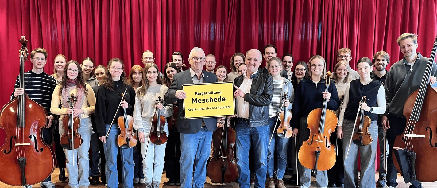 Junges Kammerorchester Meschede mit Streichinstrumenten vor rotem Bühnenvorhang