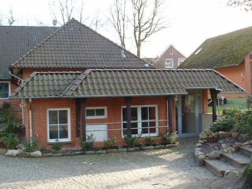 Schießstand am Dörphus.jpg Kleines rotes Haus mit braunem Dach. Eingang mit Rampe und Treppen.