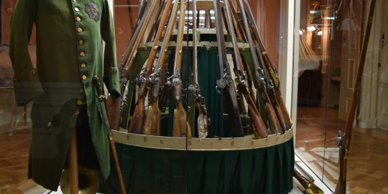 Vitrine mit Pirschrock und Jagdwaffen.