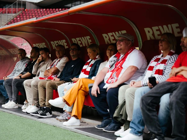 Stadium tour Visitors sit on the trainer's bench in the stadium during a guided tour.
