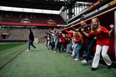 Stadionführung Eine Gruppe jubelt am Fußballrand in der Spielerkabine.
