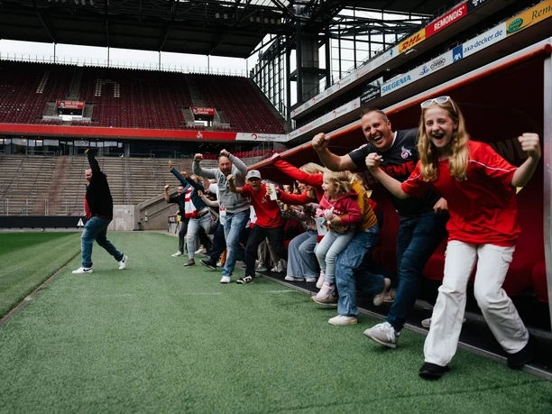 Stadium tour A group cheers on the soccer sidelines in the players' dressing room.