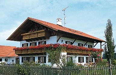 Archenhof.jpg Ein Bauernhaus mit rotem Dach und vielen Blumen. Der Ort wirkt einladend.