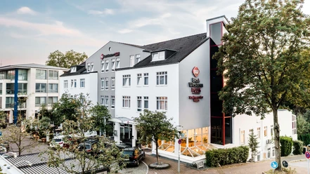 Außenansicht vom Best Western Plus Hotel Stadtquartier in Haan Außenansicht des Best Western Plus Hotel Stadtquartier Haan. Helle Fassade mit mehreren Fenstern, umgeben von Bäumen.
