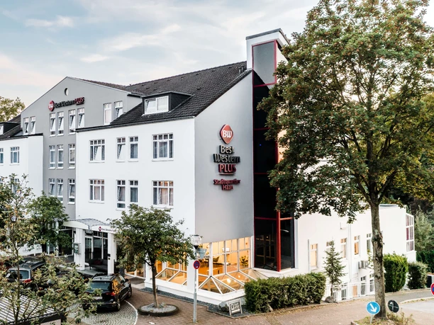 Außenansicht vom Best Western Plus Hotel Stadtquartier in Haan Außenansicht des Best Western Plus Hotel Stadtquartier Haan. Helle Fassade mit mehreren Fenstern, umgeben von Bäumen.