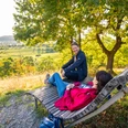 willebadessen-schmetterlingspfad-teutoburger-wald-tourismus-d-ketz-093-jpg.jpg Ein Mann und eine Frau sitzen auf einer Holzliege im Hintergrund eine schöne grüne Aussicht,