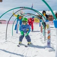 Spielerischer Parcours im Schnee Kind fährt durch Parcours im Snowgarden Riederalp mit Bögen und SpielfigurenChild rides through the course in the Snowgarden Riederalp with arches and play figuresUn enfant parcourt un parcours au Snowgarden de Riederalp avec des arches et des figurines de jeu