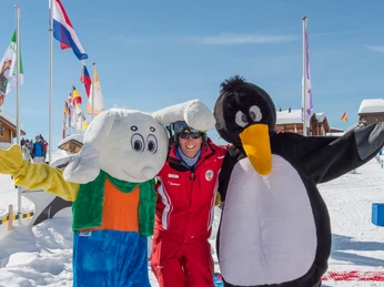 Encounter in the Snowgarden Skilehrerin steht mit Maskottchen im Snowgarden Riederalp auf dem Übungsgelände
