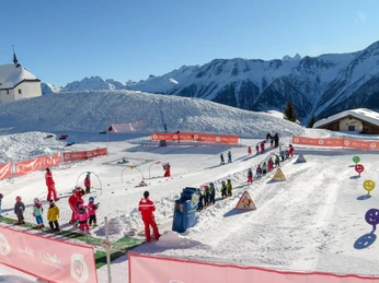 Practice area for little ski beginners Kinder üben im Snowgarden Bettmeralp auf gesichertem Lernareal mit Förderband und spielerischen ElementenChildren practise in the Snowgarden Bettmeralp on a secure learning area with conveyor belt and playful elementsLes enfants s'entraînent au Snowgarden Bettmeralp sur une zone d'apprentissage sécurisée avec tapis roulant et éléments ludiques.