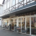 Café Feldhaus Außenansicht des Cafés mit großen Fenstern, Vordach und zwei kleinen Sitzplätzen.