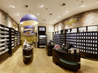 Ronnefeldt Myzeil Panoramaansicht des Ronnefeldt Teeshops mit Regalen, Tassen und TresenPanoramic view of the Ronnefeldt tea shop with shelves, cups and counters