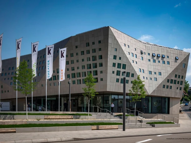 kING Kultur- und Kongresshalle - Außenansicht Außenansicht Kongresshalle in grauen Tönen bei Tag mit Flaggen am Haupteingang.