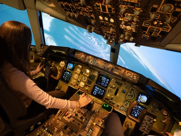 Cockpit simulator flight - Cockpit view A lady operates the instruments in a cockpit.