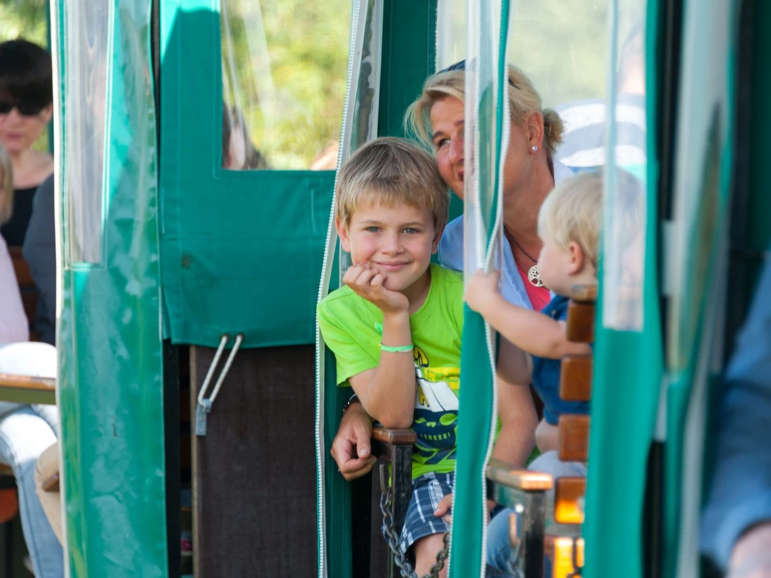 Moorbahn Ahlenmmor Frau mit zwei Kindern lächelt während einer Moorbahnfahrt durch das Ahlenmoor bei Wanna.