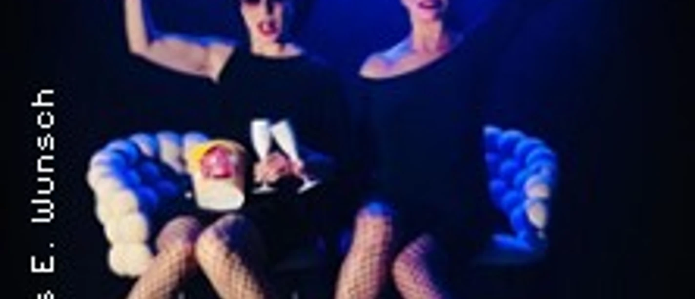 Zwei elegant gekleidete Frauen posieren auf Sesseln vor blauem Juke Box Divas Schriftzug