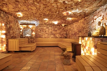 Mediterana Himalaya Salzstollen Blick in eine Sauna mit Salzblöcken an den Wänden und hellen Holzbänken.