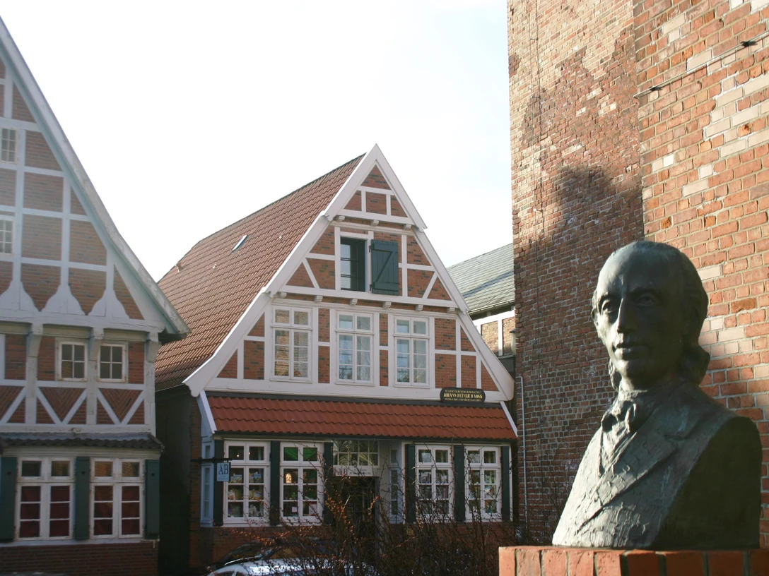 IMG_5492.JPG Eine Bronzefigur steht vor alten Fachwerkhäusern in Otterndorf.