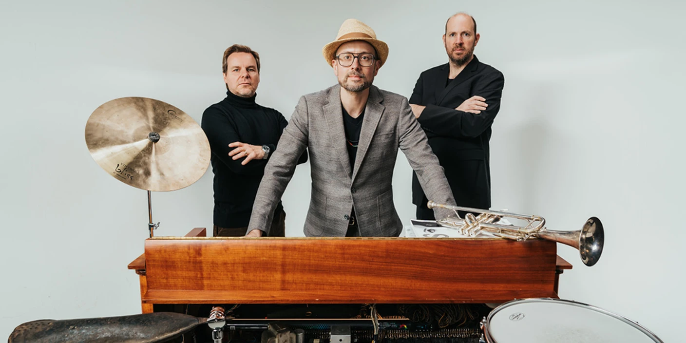 Benedikt Hesse Trio Drei Musiker stehen hinter einem alten Keyboard mit Trommel, Becken und einer Trompete