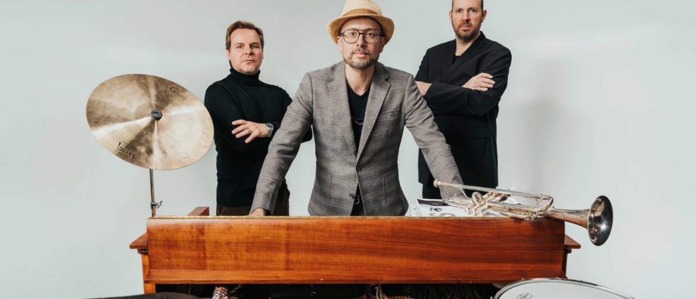 Benedikt Hesse Trio Drei Musiker stehen hinter einem alten Keyboard mit Trommel, Becken und einer Trompete