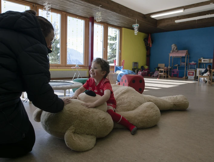 La sécurité à la garderie Betreuungsperson spielt mit Kind im Kinderhort Bettmeralp in warmer und vertrauensvoller AtmosphäreCaregiver plays with child in the Bettmeralp crèche in a warm and trusting atmosphereLa personne qui s'occupe de l'enfant joue avec lui à la garderie de Bettmeralp dans une atmosphère chaleureuse et de confiance.