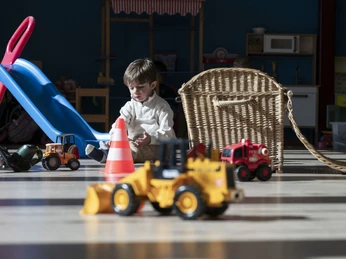 Freies Spielen im Kinderhort Kleinkind spielt mit Fahrzeugen im Kinderhort Bettmeralp in ruhiger und geschützter UmgebungToddler plays with vehicles in the Bettmeralp day nursery in a quiet and protected environmentUn petit enfant joue avec des véhicules à la garderie de Bettmeralp dans un environnement calme et protégé