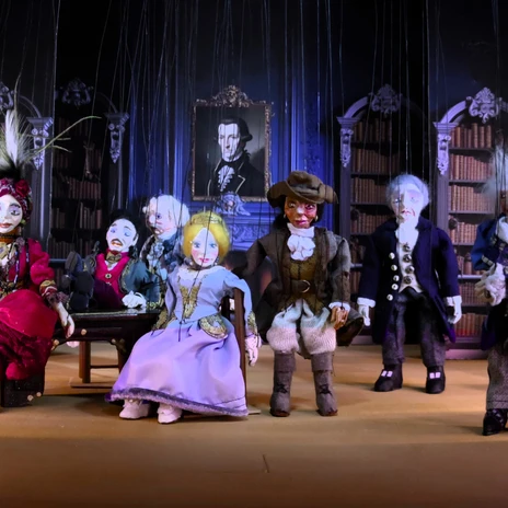 Szene aus dem Stück Die Erben des Articus Crane ©Lingener Marionettentheater im Professorenhaus e.V. .jpg Mehrere historische Marionettenfiguren in farbenprächtigen Kostümen auf einer Theaterbühne.