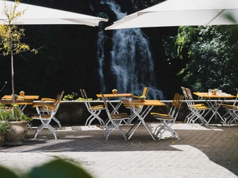 grandhotel-giessbach-terrasse-tische-schirme-wasserfall.jpg