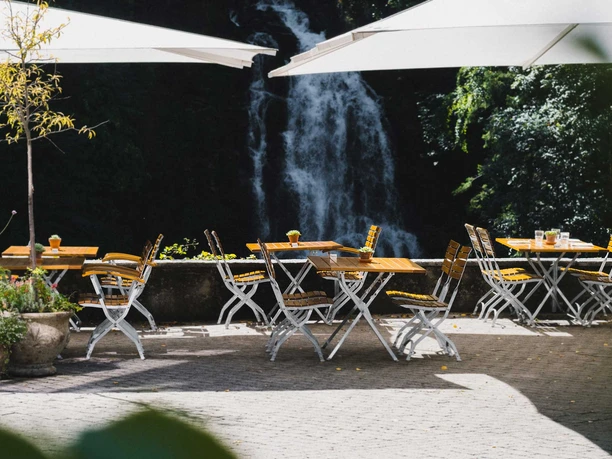 grandhotel-giessbach-terrasse-tische-schirme-wasserfall.jpg