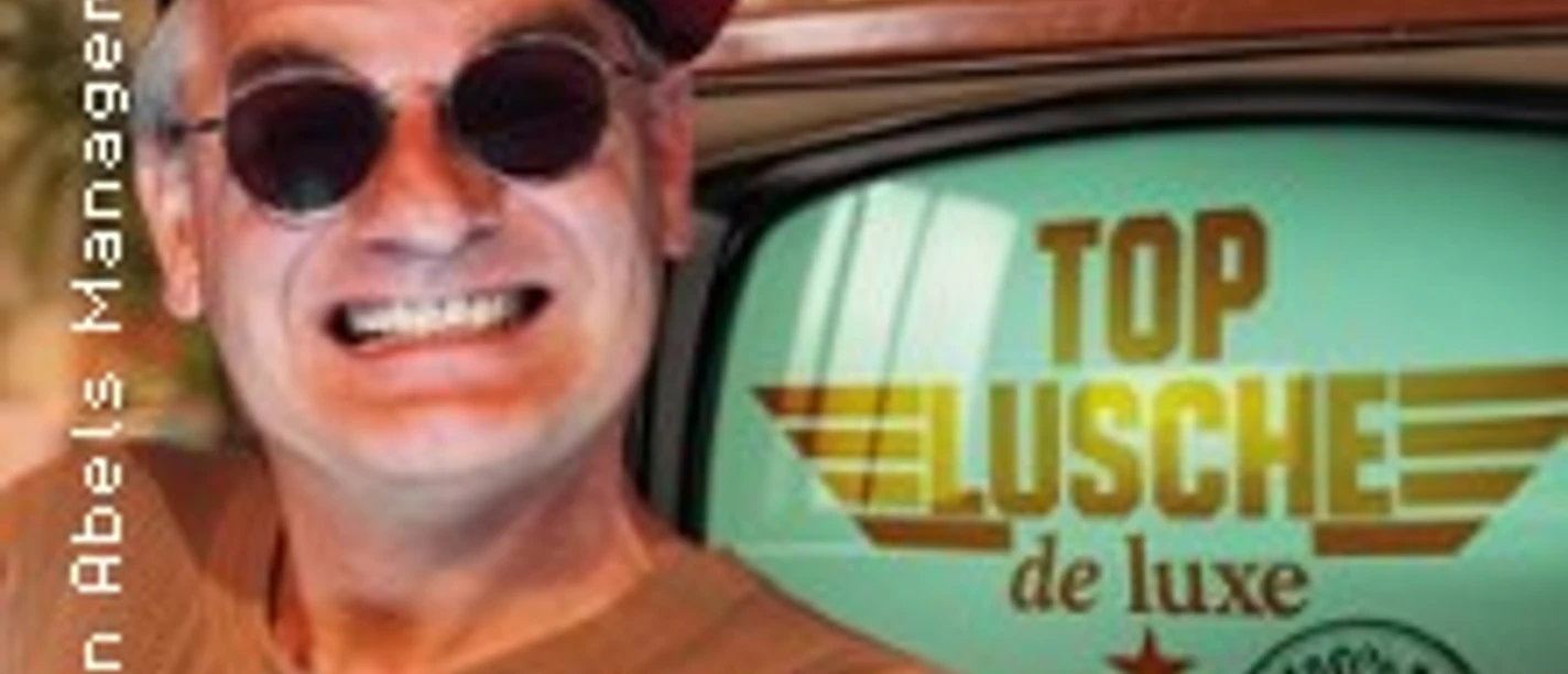 Lachender Mann mit rotem Barett vor Bildschirm mit Schriftzug Top Lusche de luxe
