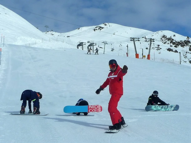 Practicing on the beginners' slope Children practise on a wide beginners' slope in the Fiescheralp snowboard taster course