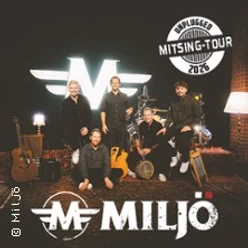 Fünf Musiker sitzen und stehen vor Instrumenten in einem warm beleuchteten Studio mit Miljö-Logo