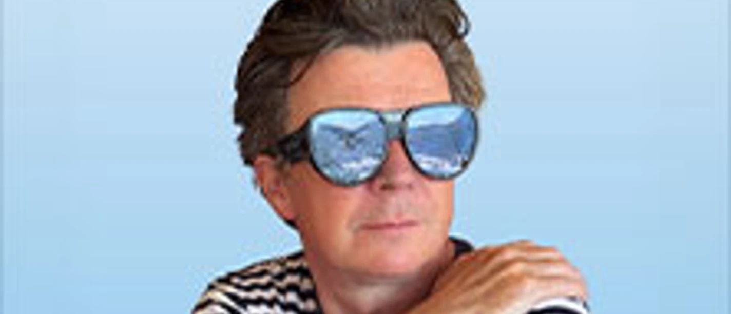 Person mit gestreiftem Shirt und Sonnenbrille vor blauem Hintergrund, Schriftzug Rick Astley