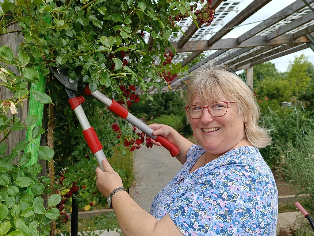 Workshop_Barbara_Siebrecht_klein_C_Huxarium_Gartenpark_Höxter.jpg Frau mit Heckenschere am Rosenstrauch