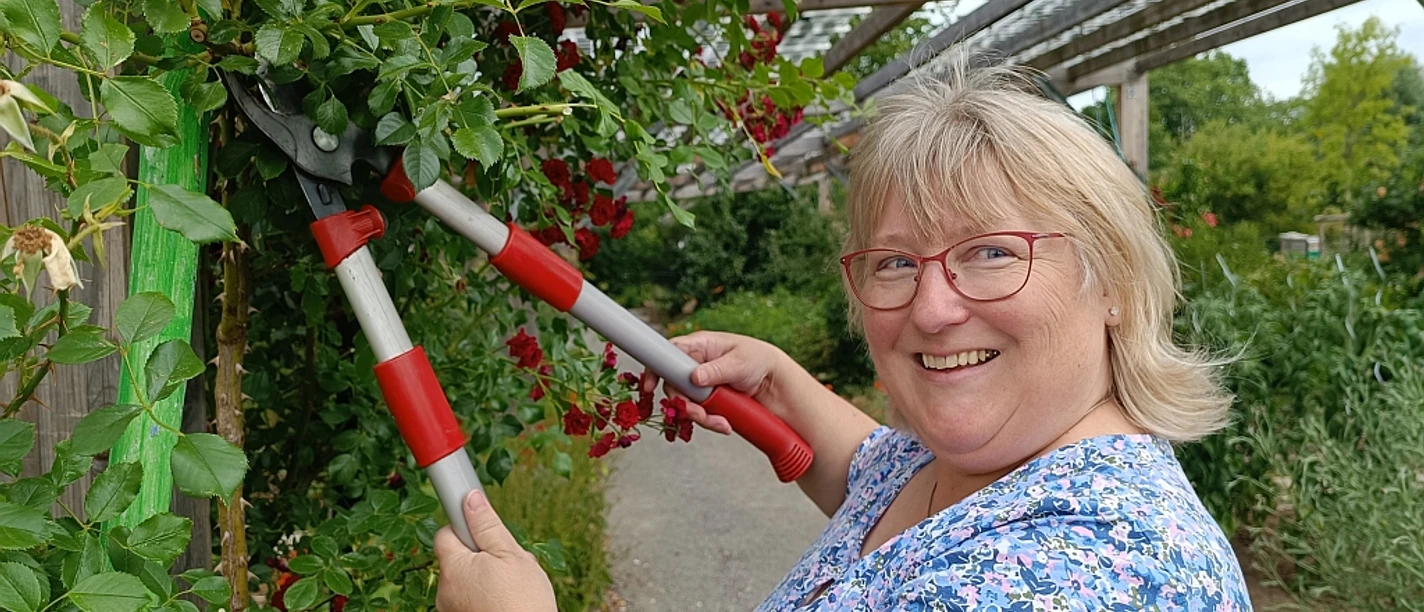 Workshop_Barbara_Siebrecht_klein_C_Huxarium_Gartenpark_Höxter.jpg Frau mit Heckenschere am Rosenstrauch