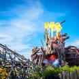 heide-park-resort-soltau-biest-colossos.jpg Feuerspeiendes Colossos-Holzachterbahn-Monster im Heide Park Soltau Resort unter blauem Himmel.