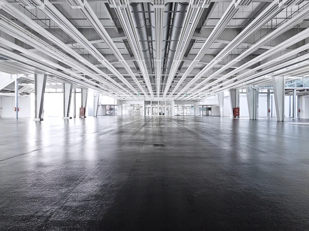 Messe Offenbach - Messehalle Ansicht einer leeren Messehalle mit weißen Wänden und grauem Boden.