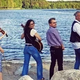 1 Band to Chill.jpg Vier Musiker mit Geige und Gitarren stehen am Ufer eines Sees und blicken lächelnd zur Kamera.