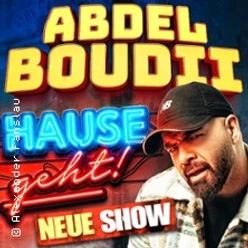 Werbeplakat mit einem bärtigen Mann in Kappe vor bunten Schriftzügen zur neuen Show