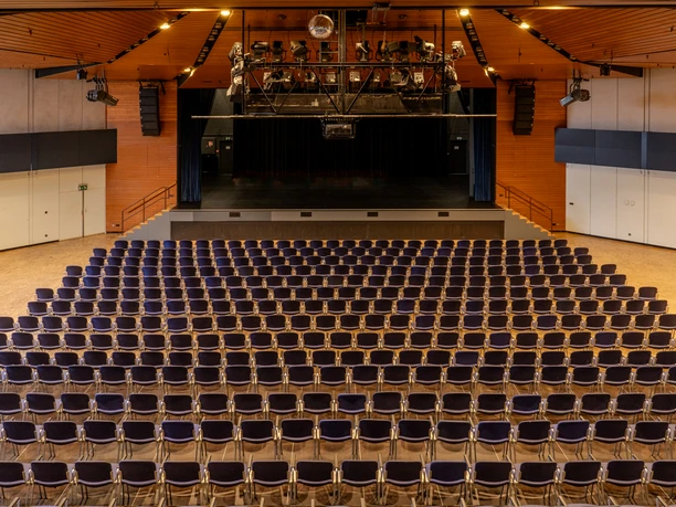 Hugenottenhalle - Halle Große Halle mit Reihenbestuhlung und Blick auf die Bühne.