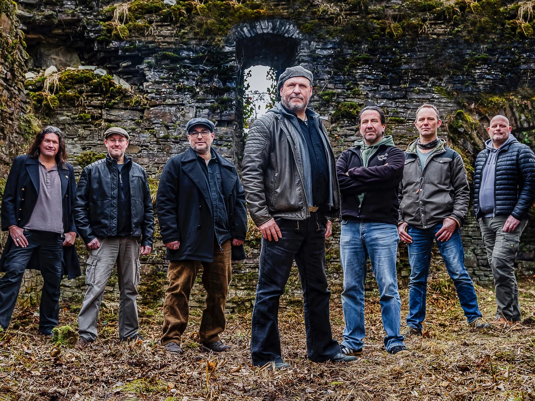 Anduril-Bandfoto.jpeg Sieben Männer der Band Anduril stehen vor einer alten Steinruine, in Freizeitkleidung und Jacken.