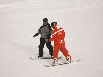 Individuelle Snowboardbetreuung auf der Bettmeralp Schweizer Skischule Bettmeralp erklärt einem Snowboard-Anfänger Technik und Balance während des SchnupperkursesSwiss Ski School Bettmeralp explains technique and balance to a snowboard beginner during the taster courseL'École Suisse de Ski de Bettmeralp explique à un débutant en snowboard la technique et l'équilibre lors d'un cours d'essai