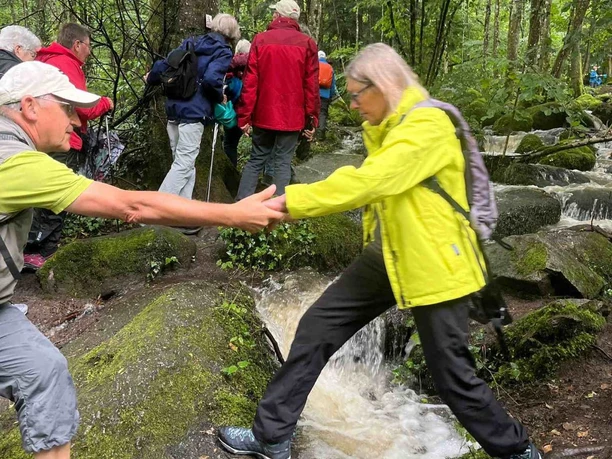 Wanderin beim Überqueren eines Bachlaufes