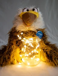 Auf dem Bild ist das Plüschtier Fritzi zu sehen - vor ihm steht ein Glas mit einer leuchtenden Lichterkette.